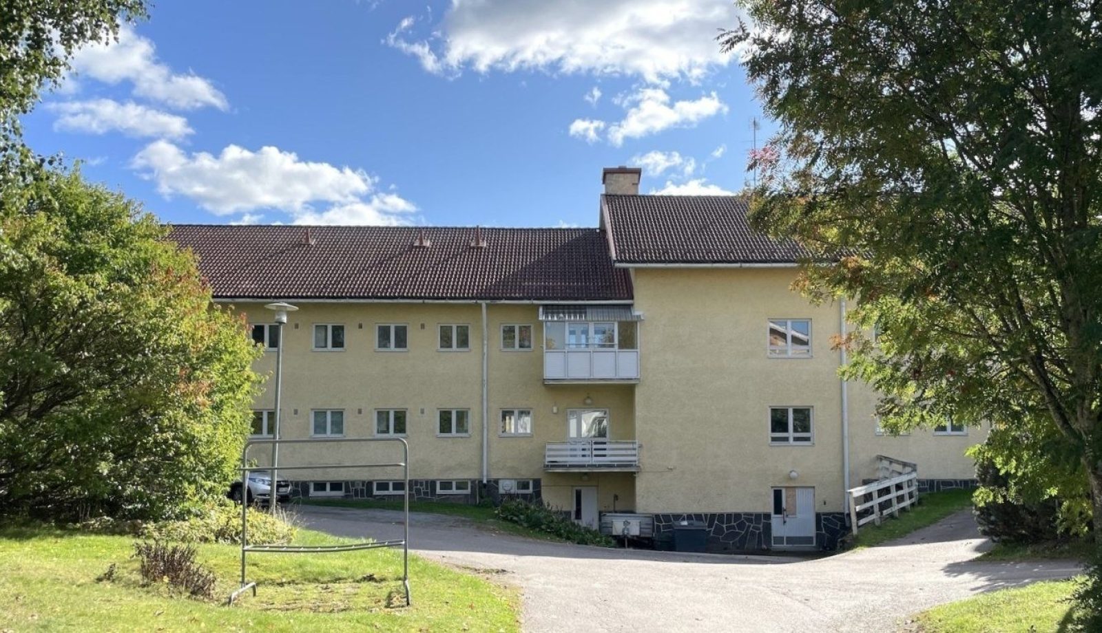 1950-luvun keltaiseksi rapattu, harjakattoinen vanhainkotirakennus.