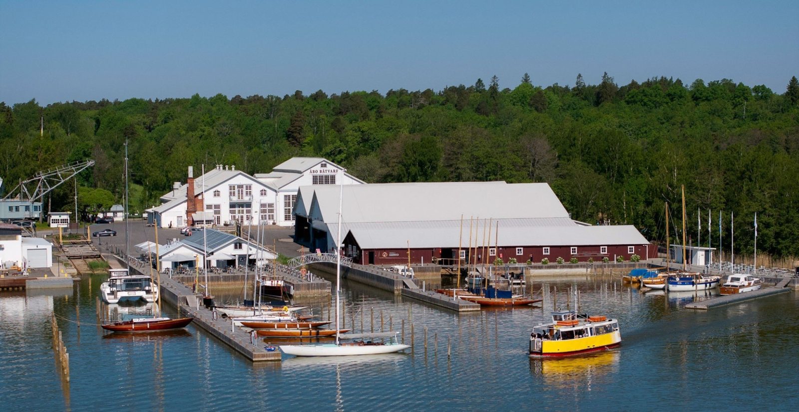 Ilmakuvassa satama ja sen rakennuksia ja veneitä.