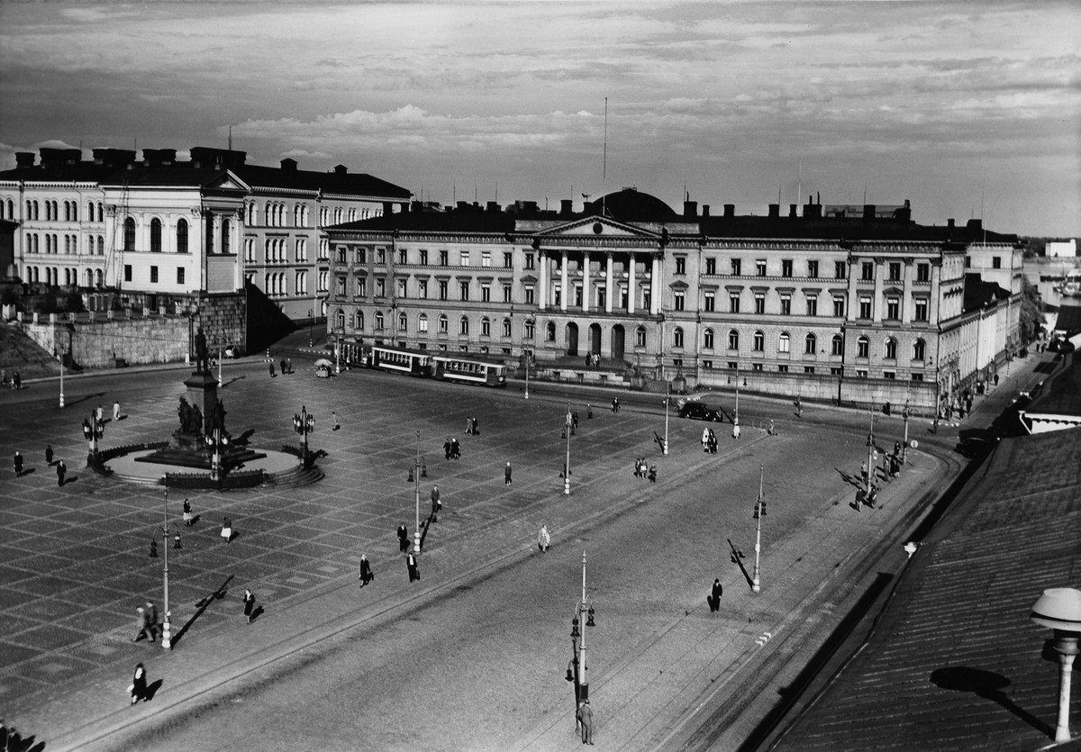 Mustavalkokuvassa lähes tyhjä tori. Taka-alalla Valtioneuvoston linna.