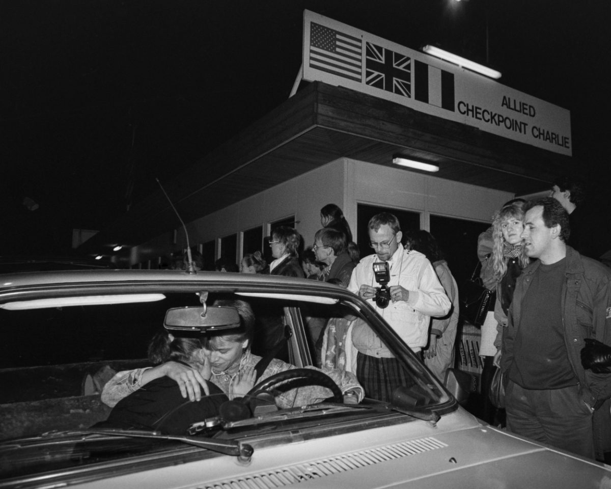 Itä-Saksasta tullut nuoripari pysähtyy suutelemaan Checkpoint Charlien rajanylityspaikalla Berliinin muurin murtumisen jälkeisenä päivänä 10.11.1989. Kuva: Hannu Lindroos / JOKA / Museovirasto