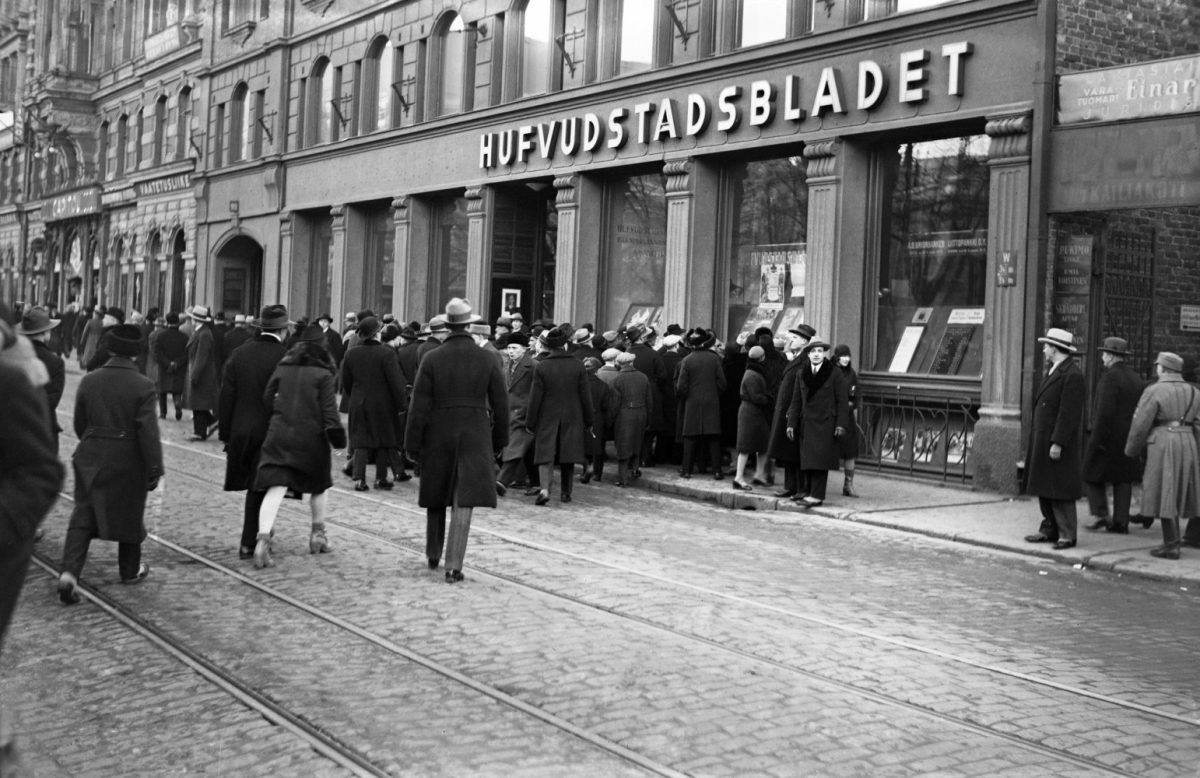 Ihmiset lukevat uutisia Hufvudstadsbladetin konttorin ikkunasta Heikinkadulla Helsingissä 4.3.1930. Kuva: Hugo Sundström / HBL / Journalistinen kuva-arkisto JOKA / Museovirasto