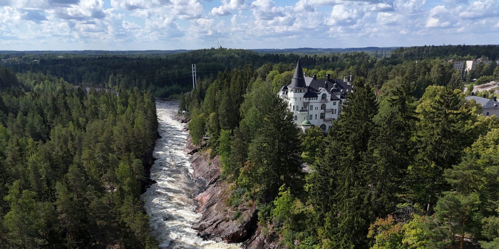Ilmakuva Imatrankoskesta, ympärillä metsää ja historiallinen rakennus. Ilmakuva Imatrankoskesta, ympärillä metsää ja historiallinen rakennus.