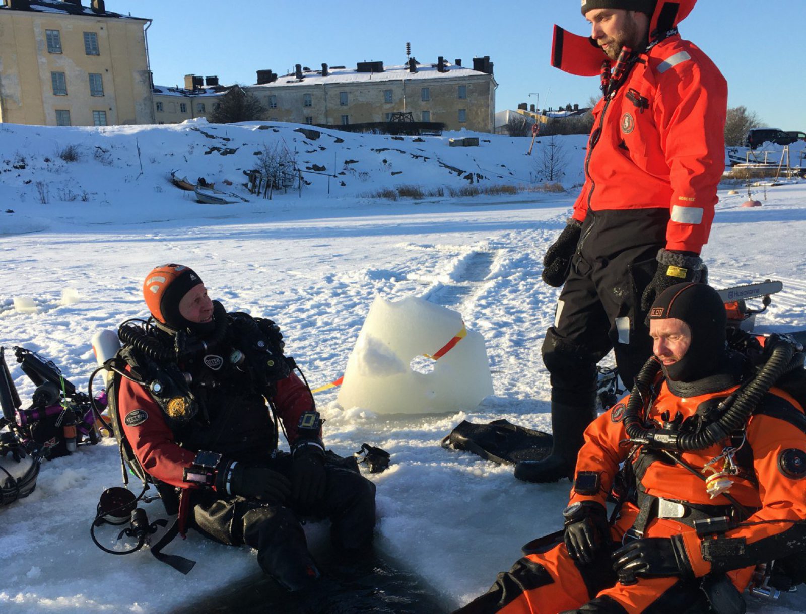 Sukeltajia istumassa talvivarusteissa avannon äärellä Suomenlinnan edustalla.rellä S. Kuvaaja: Minna Koivikko, Museovirasto. Sukeltajia istumassa talvivarusteissa avannon äärellä Suomenlinnan edustalla.rellä S. Kuvaaja: Minna Koivikko, Museovirasto.